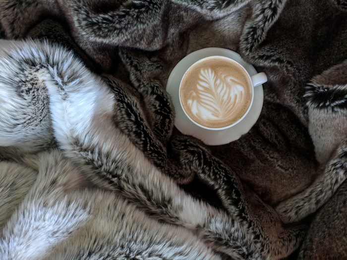 Latte art coffee on a furry blanket