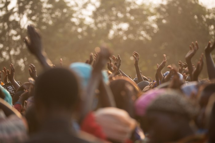 Crowd raising hands in praise and worship outdoors
