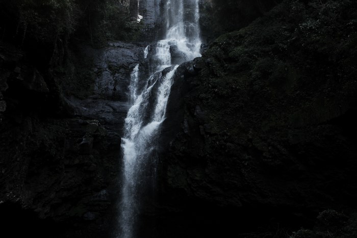 Dark waterfall cascading down a rocky cliff