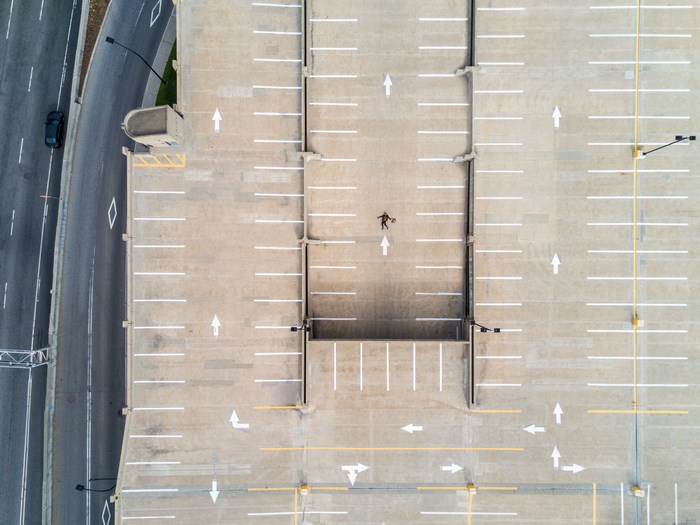 Aerial View of Empty Rooftop Parking with Person Lying Down