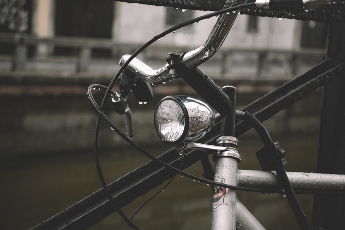 Wet bicycle with a chrome headlight on a rainy day