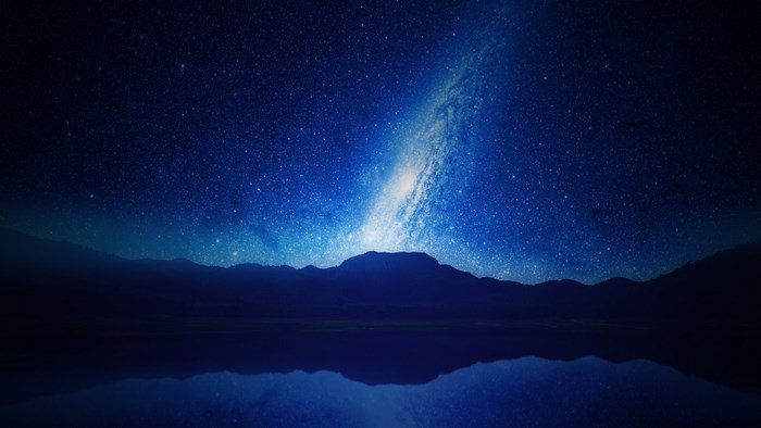 Galaxy over mountains and lake at night