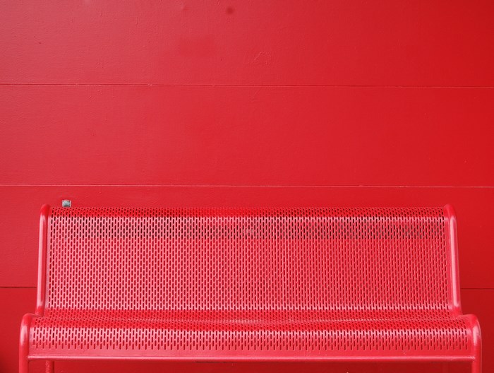 Red bench against a red wall