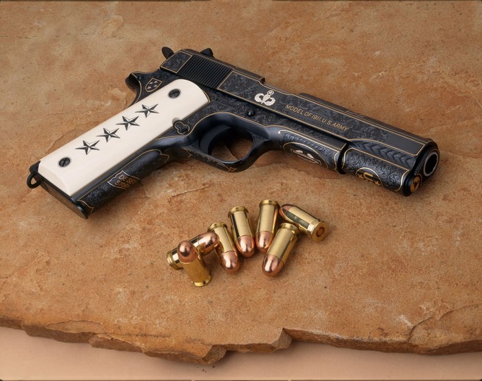 Colt 1911 Pistol with Ammunition on Stone Surface