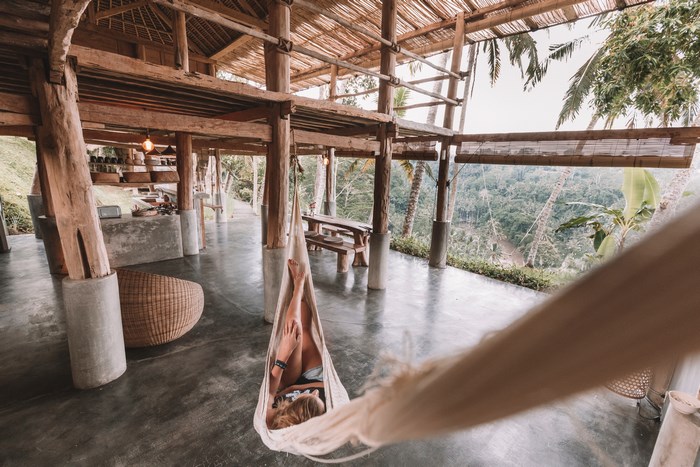 Woman relaxing in a hammock overlooking a jungle in Ubud