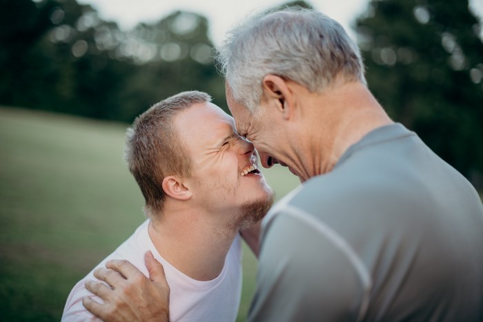 Father and son embracing and laughing outdoors
