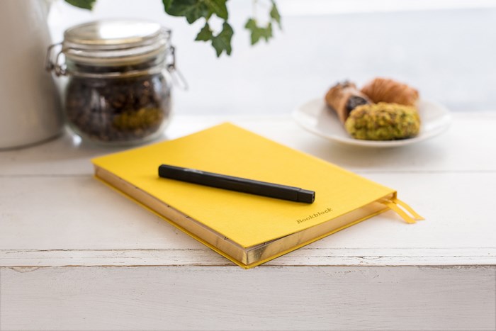 Yellow Bookblock notebook with pen and pastries