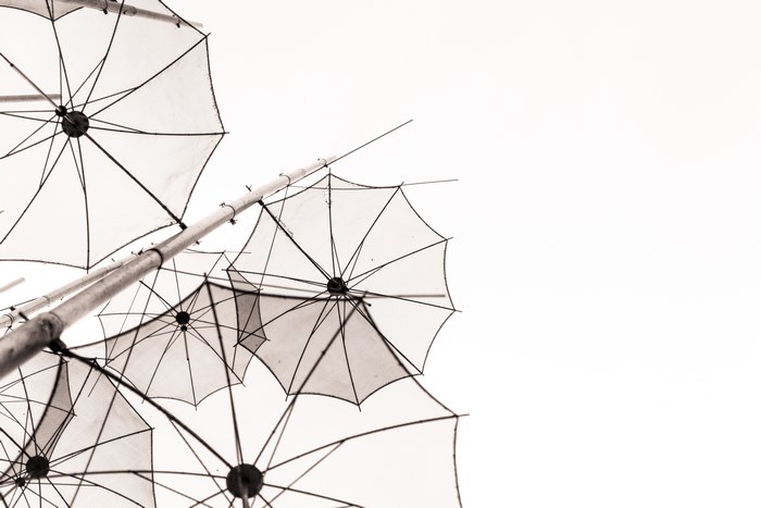 Black and white image of umbrellas against the sky