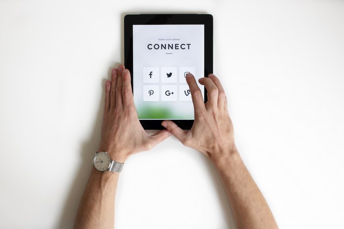 Hands Using Tablet Showing Social Media Icons