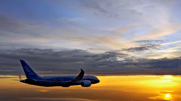 Boeing 787 Dreamliner flying at sunset