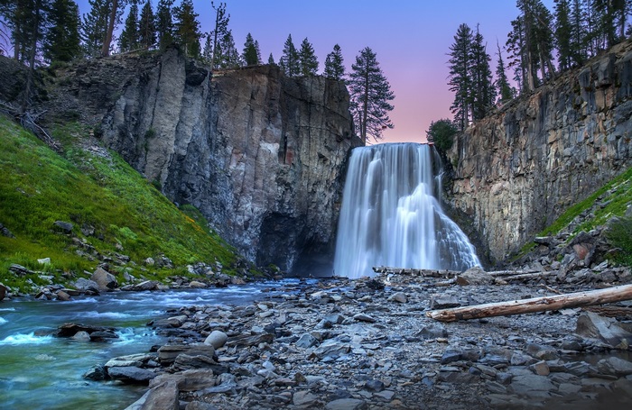 Serene Waterfall Amidst Rocky Cliffs at Twilight