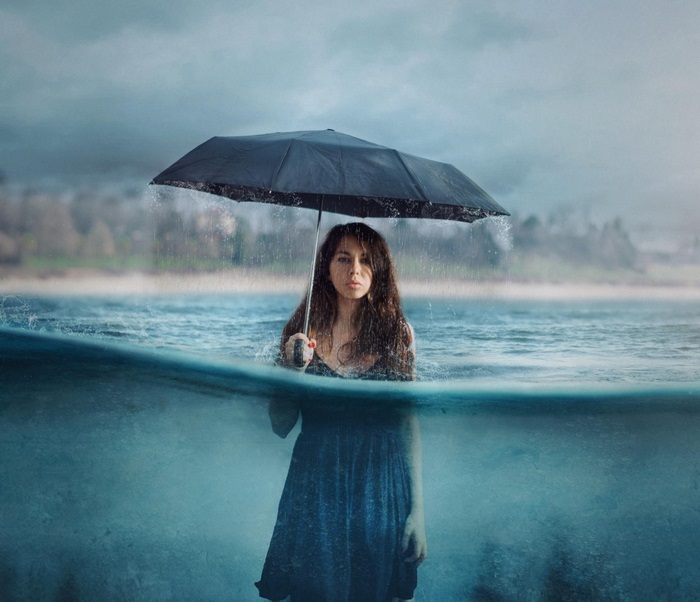 Woman Holding Umbrella in Water