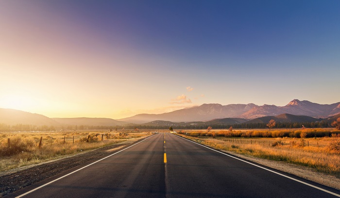 Empty road at sunset with mountains