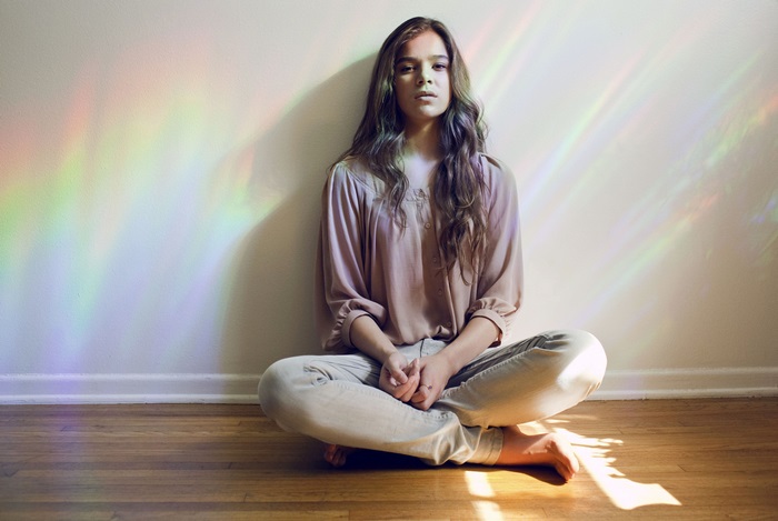 Hailee Steinfeld sitting on floor with rainbow light