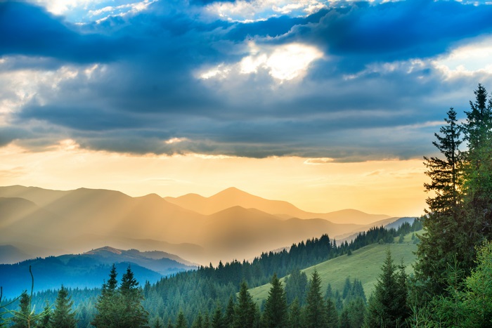 Mountain range with sunbeams and clouds