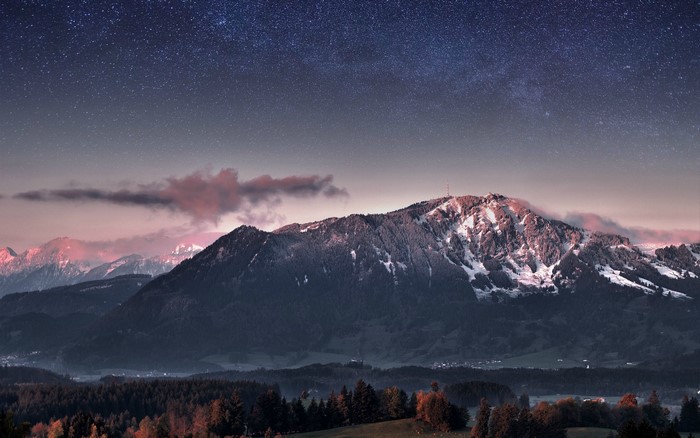 Mountain range under starry sky at dusk