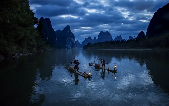 Fishermen on boats with lanterns on a river in China