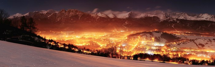 Winter valley lights at night with mountains