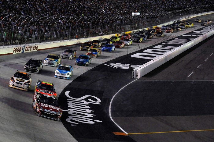 NASCAR race cars on track at night