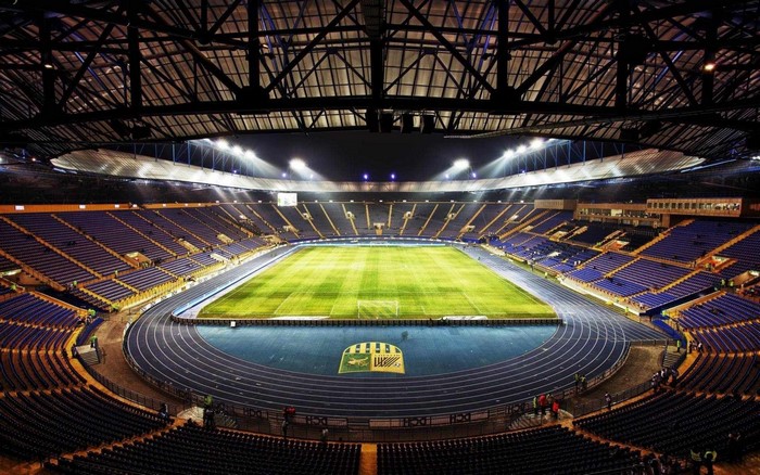 Soccer stadium with blue seats and green field