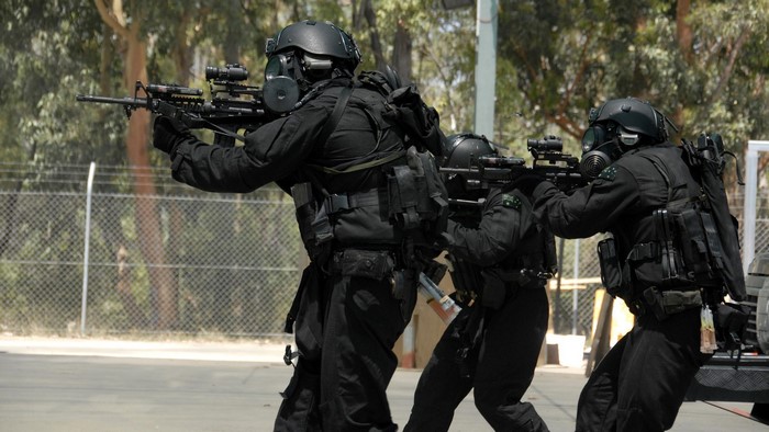 Australian commandos in tactical gear with gas masks