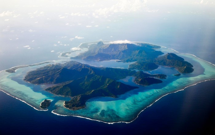Aerial view of a tropical island with mountains and a lagoon