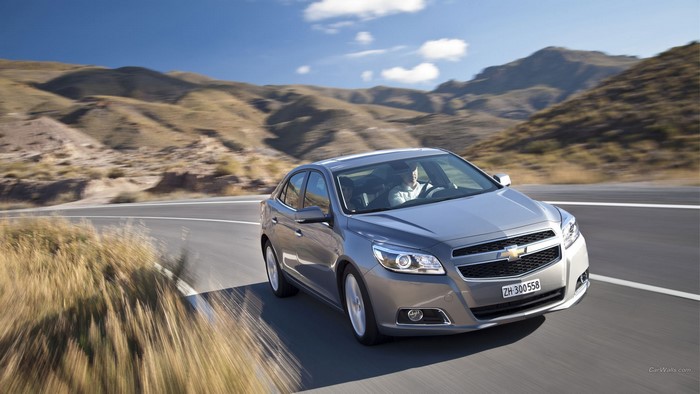 Silver Chevrolet Malibu driving on a mountain road