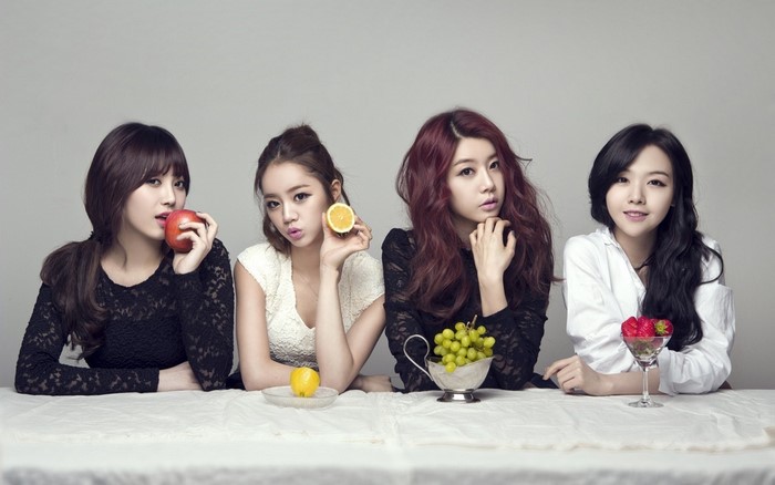 Four Asian women with fruit on a table