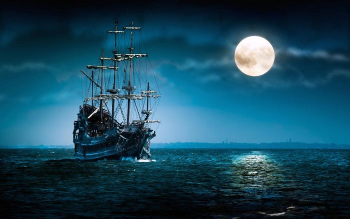Pirate ship sailing under a full moon