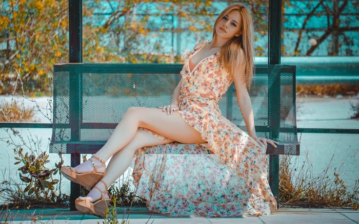 Woman Sitting on Bench Wearing Floral Dress