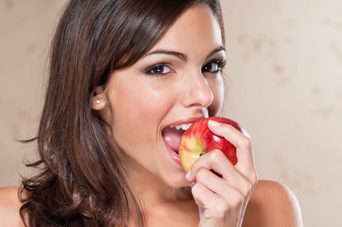 Woman eating a red apple