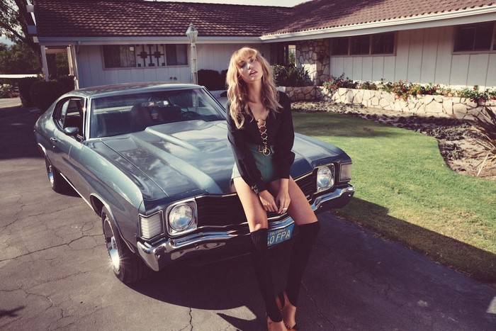 Woman posing on a vintage Chevrolet Chevelle