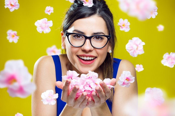Woman with glasses holding pink flowers