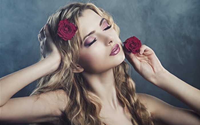 Woman with blonde wavy hair and red roses
