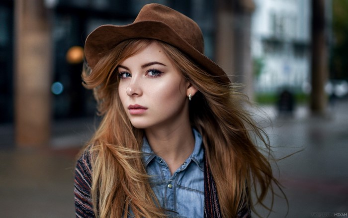 Woman wearing a hat and denim shirt