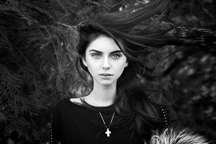Woman with windblown hair and cross necklace