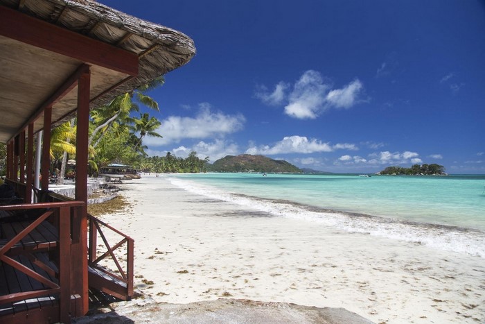 Tropical beach bungalow with white sand and turquoise sea in Seychelles
