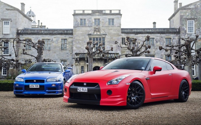 Nissan GT-R R34 and R35 in front of a mansion