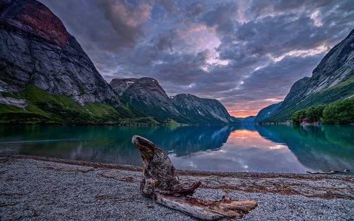 Lake and mountains at sunset with driftwood