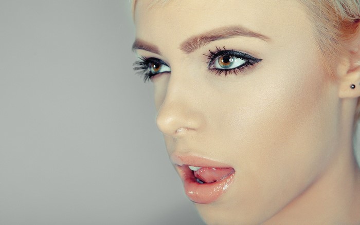 Woman with blonde hair licking her lips