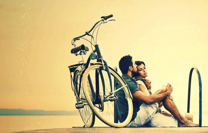 Couple with bicycle by the water