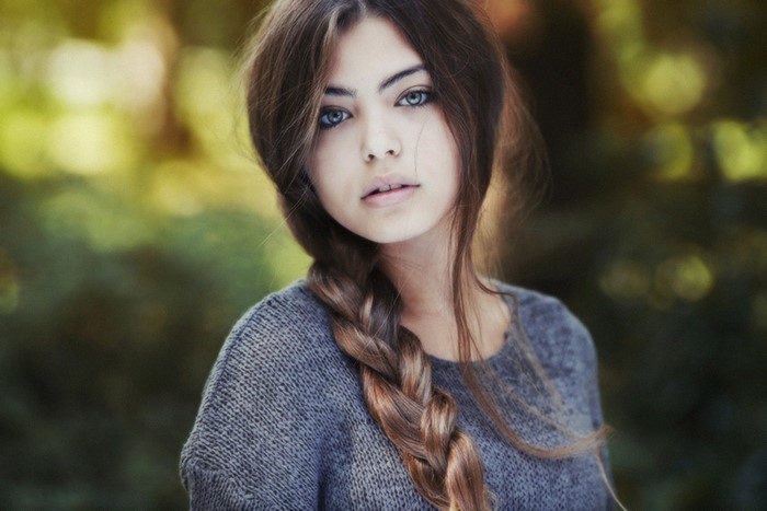 Woman with braided hair and blue eyes outdoors