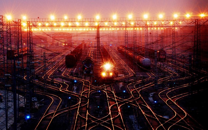 Train yard at night with lights and trains