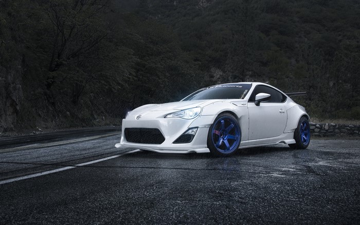 White Scion FR-S tuned car on a wet road