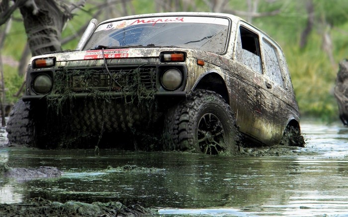 Muddy Lada Niva driving through water