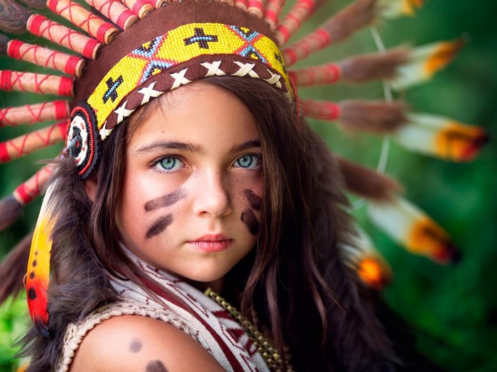 Young girl in Native American headdress with face paint