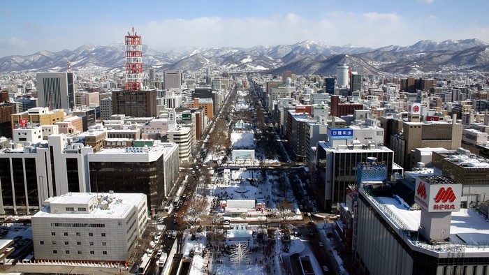 Sapporo, Japan cityscape with snow-covered mountains