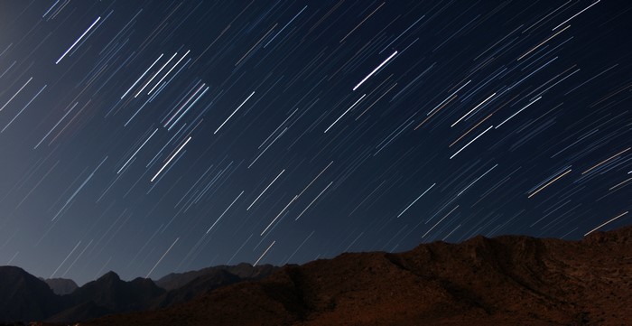 Star trails over mountains at night