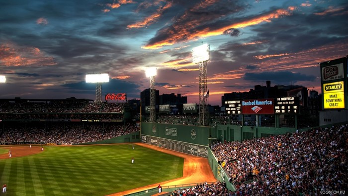Baseball stadium at sunset with crowds and Coca-Cola sign