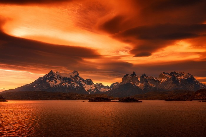 Amber sunset over snowy mountains and lake in Torres del Paine